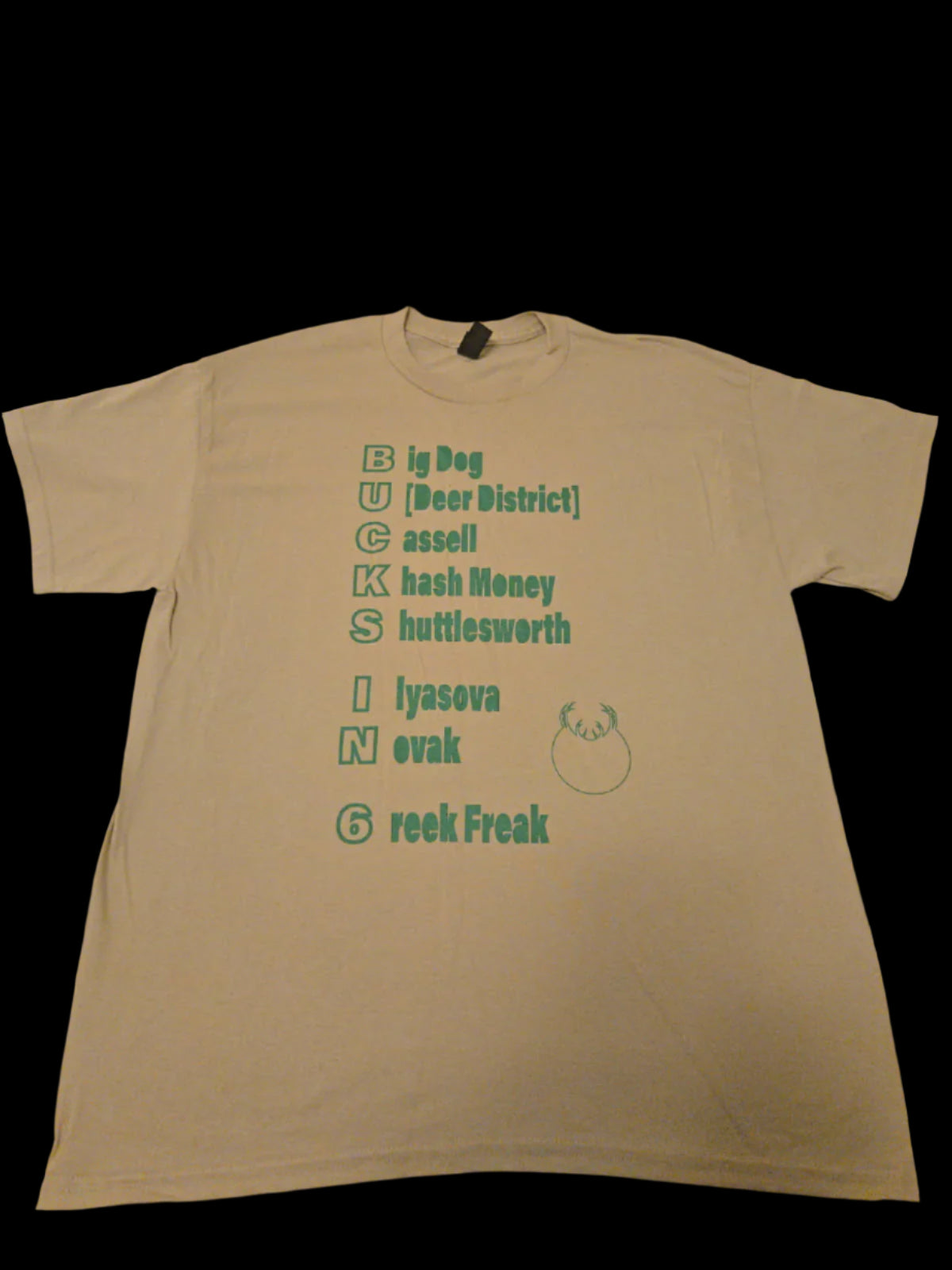 Beige t-shirt with green text and graphics on a beige background